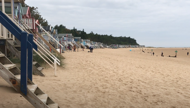 Beach huts on stilts and the sandy beach at Wells Next-the-sea in North Norfolk, UK